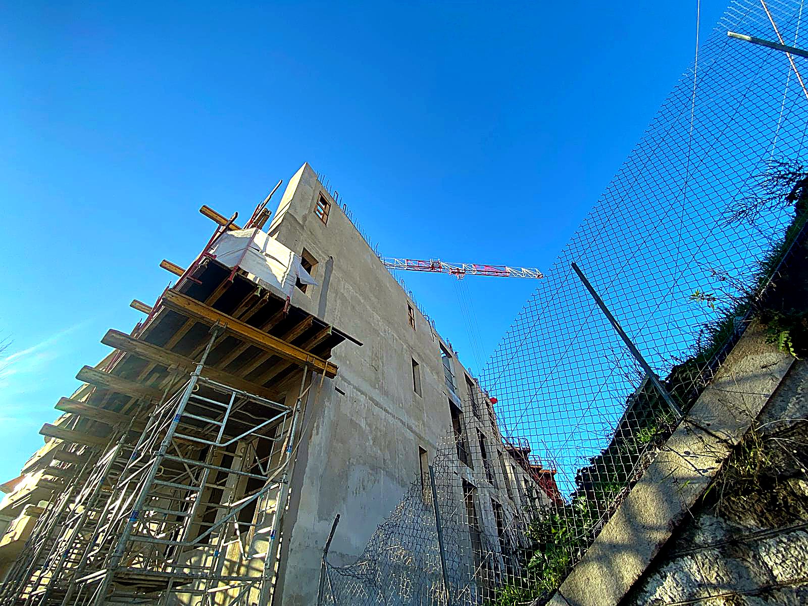 Immeuble en construction neuve avec grue, intervention électrique en cours